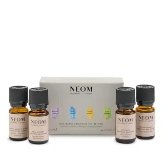 NEOM Wellbeing Essential Oil Blends set with four bottles in front of packaging.