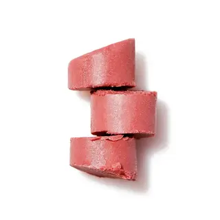 Three stacked pink solid shampoo bars on a white background.