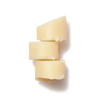Three stacked pieces of solid beige cocoa butter on a white background.