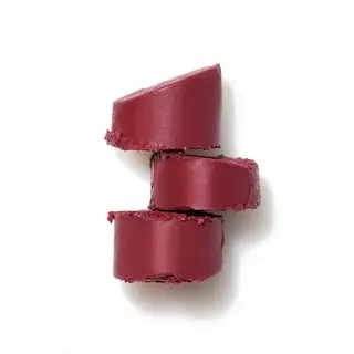 Three stacked slices of deep red lipstick on a white background.