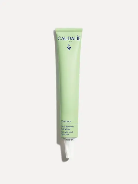 Green tube of Caudalie Vinopure Salicylic Spot Solution on white background.