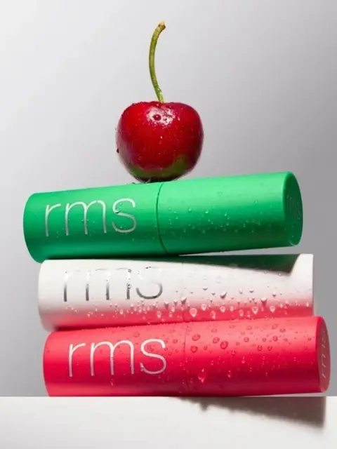 Three rms lip balms stacked with a cherry on top.