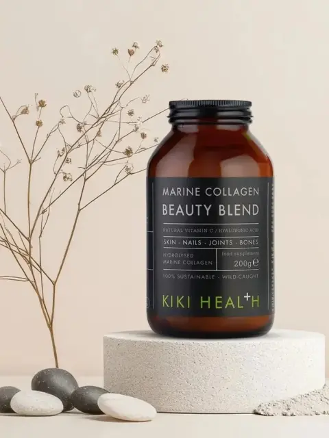 Marine Collagen Beauty Blend jar on a stone platform with pebbles and dried flowers.