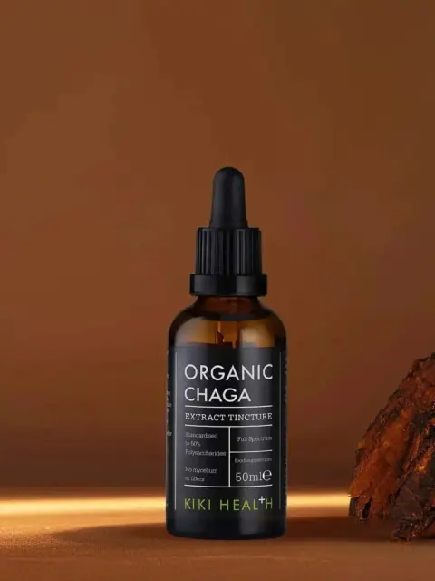 Brown bottle of Organic Chaga extract tincture, 50ml, next to chaga mushroom piece.