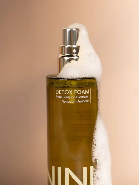 Detox Foam Pore Purifying Cleanser bottle with foam on top.