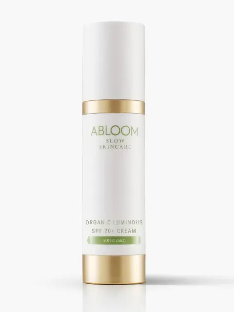 White bottle with gold accents, labelled "Abloom Slow Skincare Organic Luminous SPF 20+ Cream Sunkissed".