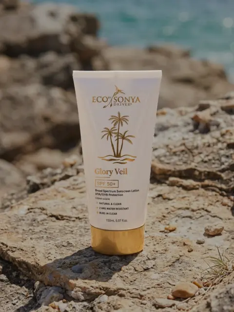 Eco by Sonya Glory Veil SPF 50+ sunscreen on rocky beach background.