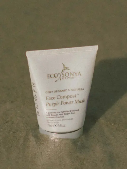 Eco Sonya Face Compost Purple Power Mask tube on sandy surface.