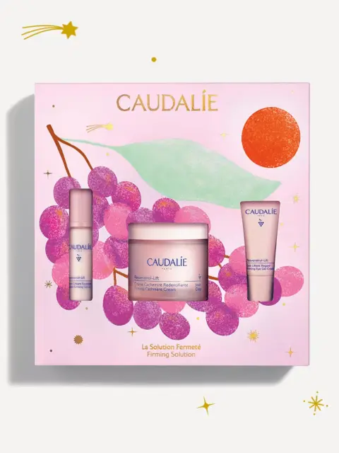 Caudalie gift set with three skincare products, grape illustration, and text "Firming Solution".