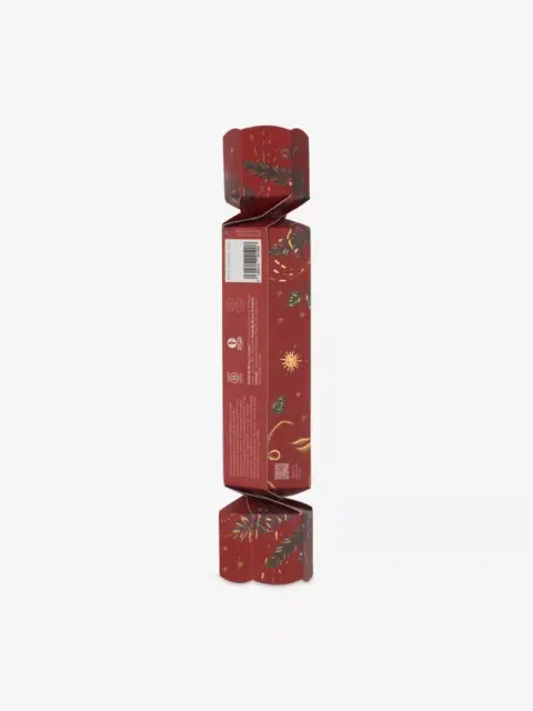 Red festive cracker with gold and green leaf design, barcode visible on side.