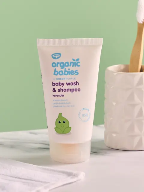 Organic Babies lavender baby wash tube on a bathroom counter with toothbrushes.