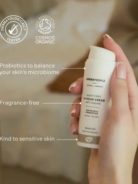 Hand holding Green People 24-hour cream. Text highlights prebiotics, fragrance-free, sensitive skin.