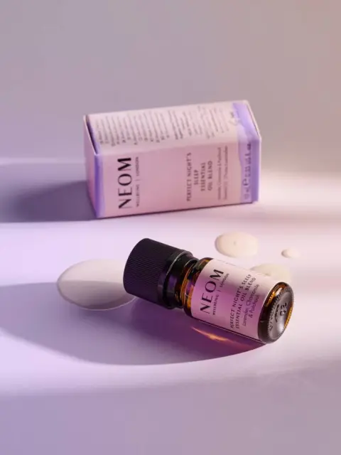 NEOM Perfect Night's Sleep oil bottle and box on a light purple surface.