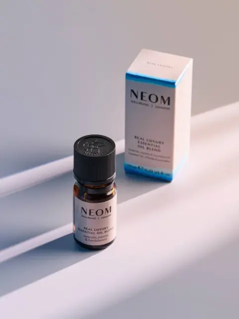 NEOM essential oil bottle and box on a light surface.