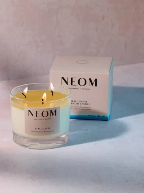 NEOM Real Luxury scented candle with box on a light surface.
