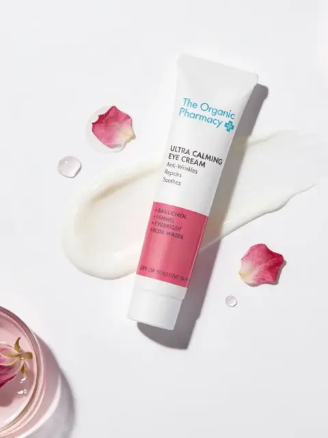 The Organic Pharmacy Ultra Calming Eye Cream with rose petals and cream smear.