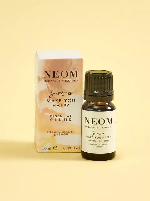 Neom Organics essential oil blend, neroli, mimosa, lemon, 10ml bottle and box on yellow background.