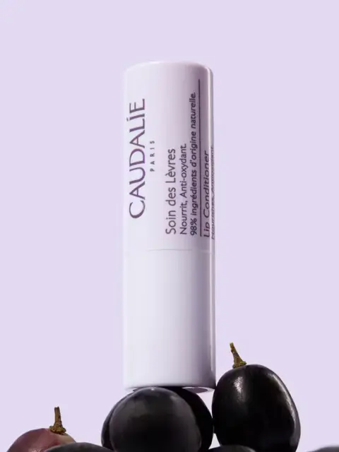 Lip conditioner tube with grapes, text in French and English.