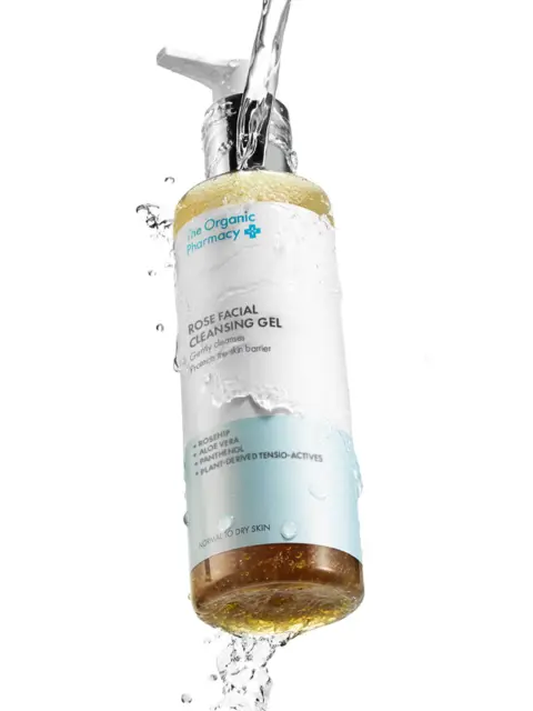 The Organic Pharmacy Rose Facial Cleansing Gel with water splashes.