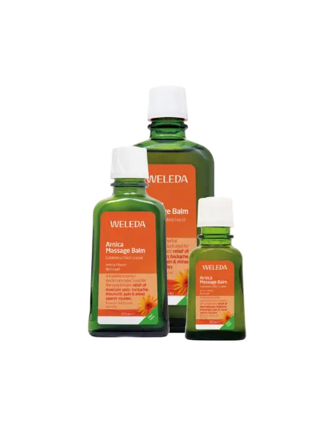 Three bottles of Weleda Arnica Massage Balm with orange labels.