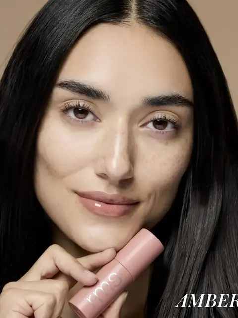 Person holding pink rms beauty product, text "AMBER" in corner.