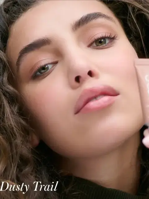 Close-up of a person holding a tube labelled "Dusty Trail".