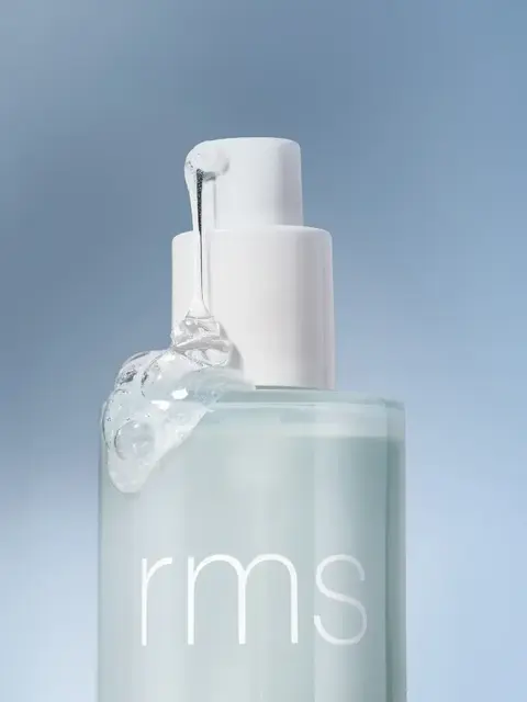 Clear bottle with "rms" text, white pump, and gel oozing out, set against a blue background.
