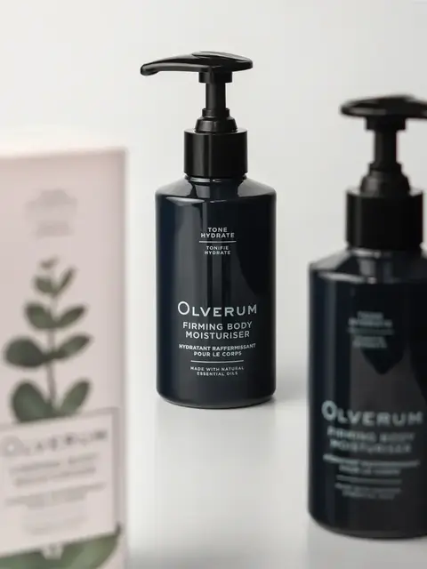 Two bottles of Olverum Firming Body Moisturiser with a box in the background.