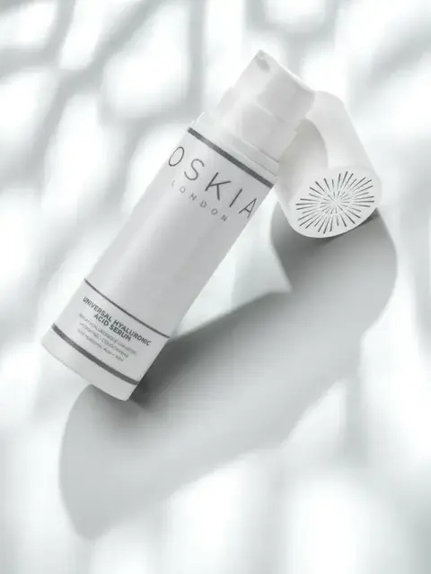 White bottle of Oskia London Hyaluronic Acid Serum on a textured white background.