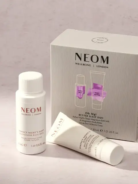NEOM Better Sleep Duo set with bath milk and body butter on a light surface.