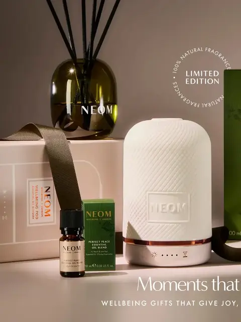 NEOM diffuser set with reed diffuser, oil blend, and packaging. Text: "Moments that Glimmer".