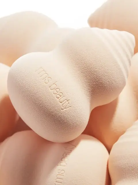 Peach-coloured makeup sponges with "rms beauty" embossed.