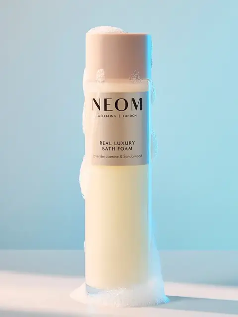 NEOM Real Luxury Bath Foam bottle with bubbles, lavender, jasmine, sandalwood scent.