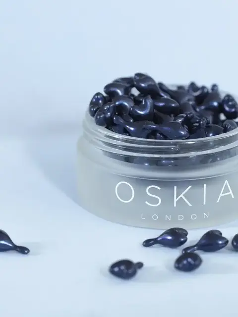 Jar of black skincare capsules labelled "OSKIA London".