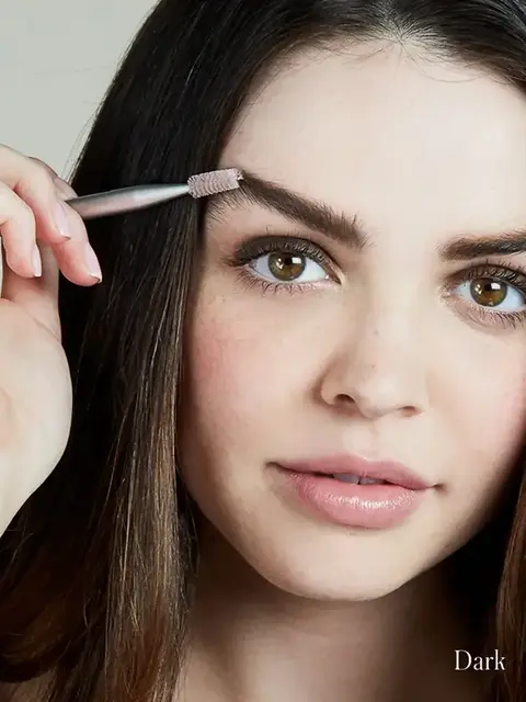 Woman using eyebrow brush, text "Dark" in corner.