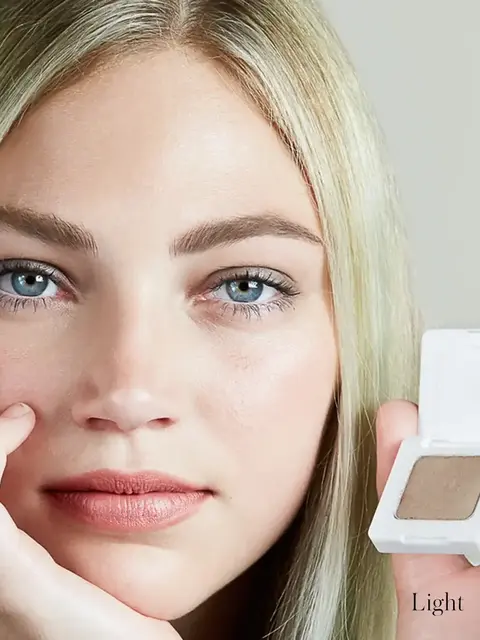 Person holding a compact with light brown eyeshadow. Text: "Light".