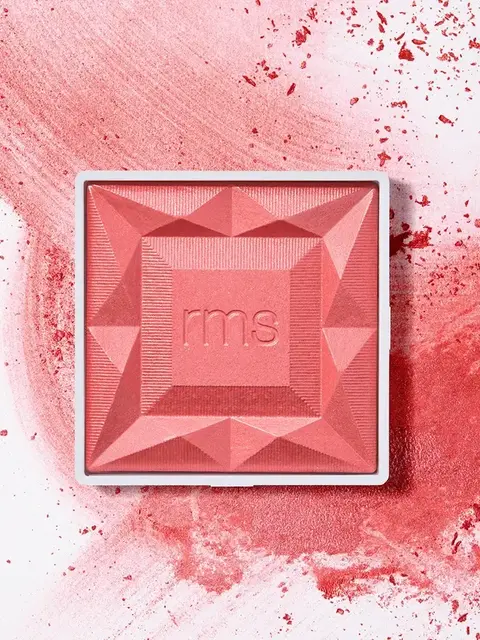 Square pink blush with "rms" embossed, surrounded by scattered powder.