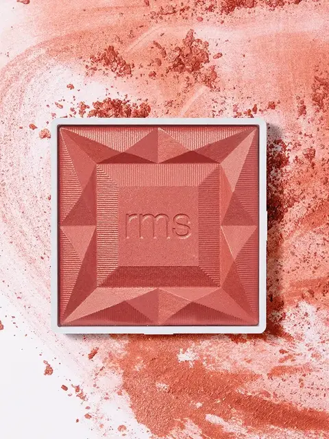 RMS Beauty blush compact on a textured pink powder background.