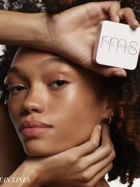 Person holding RMS Beauty compact, text "TAN LINES" in corner.