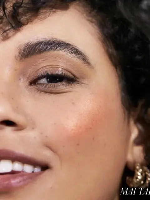 Close-up of a woman's face with peach blush on cheek. Text: "MAI TAI".