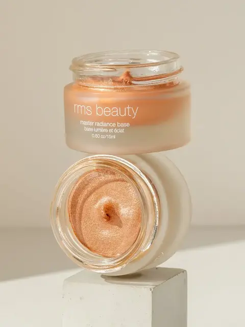 RMS Beauty Master Radiance Base in open jar on a white block.