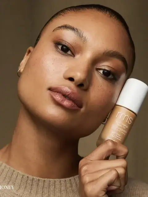 Person holding rms beauty foundation bottle labelled "Honey".