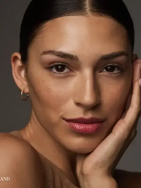 Person with smooth skin, hand on face, wearing hoop earring. Text: "SAND" in corner.