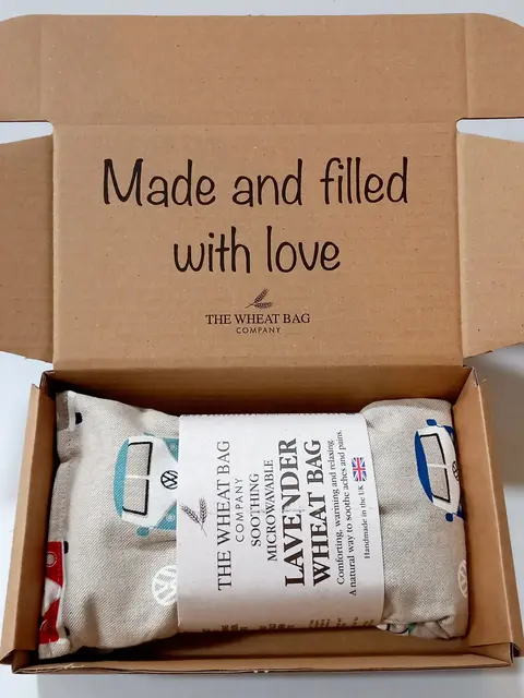 Open box with a lavender wheat bag inside. Text: "Made and filled with love".
