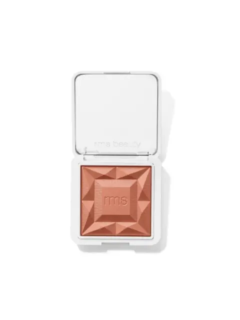 Open compact with embossed peach powder and "rms" text. White case with "rms beauty" on lid.