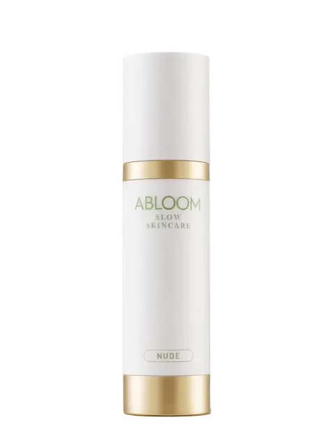 White bottle with gold accents, labelled "Abloom Slow Skincare Nude".