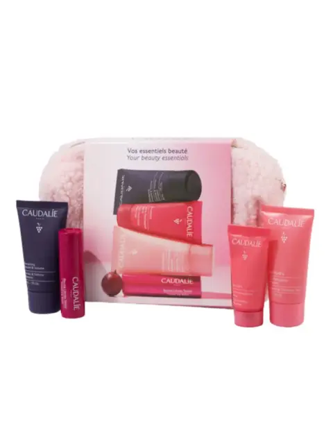Caudalie beauty essentials set with pink and purple skincare products and a fluffy pouch.