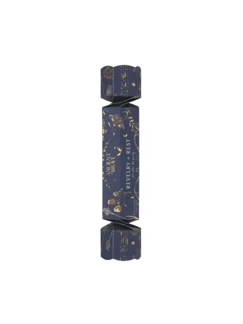 Navy and gold cracker with "Ancient + Brave" and "Revelry + Rest" text.
