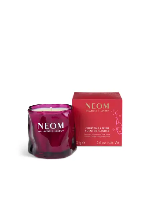 Purple NEOM candle with red box, labelled "Christmas Wish Scented Candle".