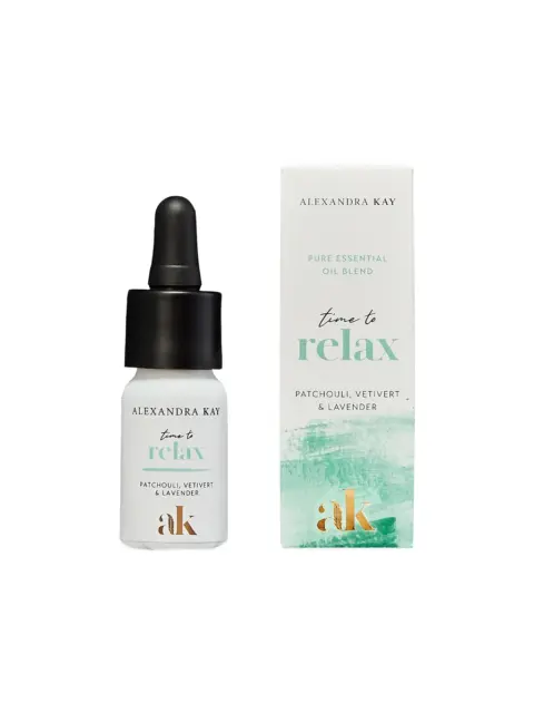 Essential oil bottle and box, labelled "time to relax" with patchouli, vetivert, and lavender.